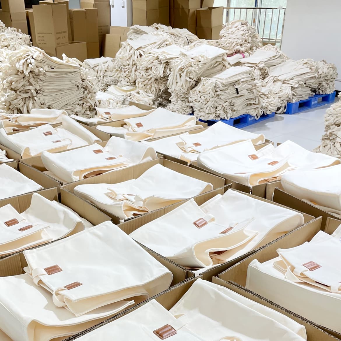 Neatly packaged organic cotton tote bags in recycled kraft paper packaging ready for export shipment