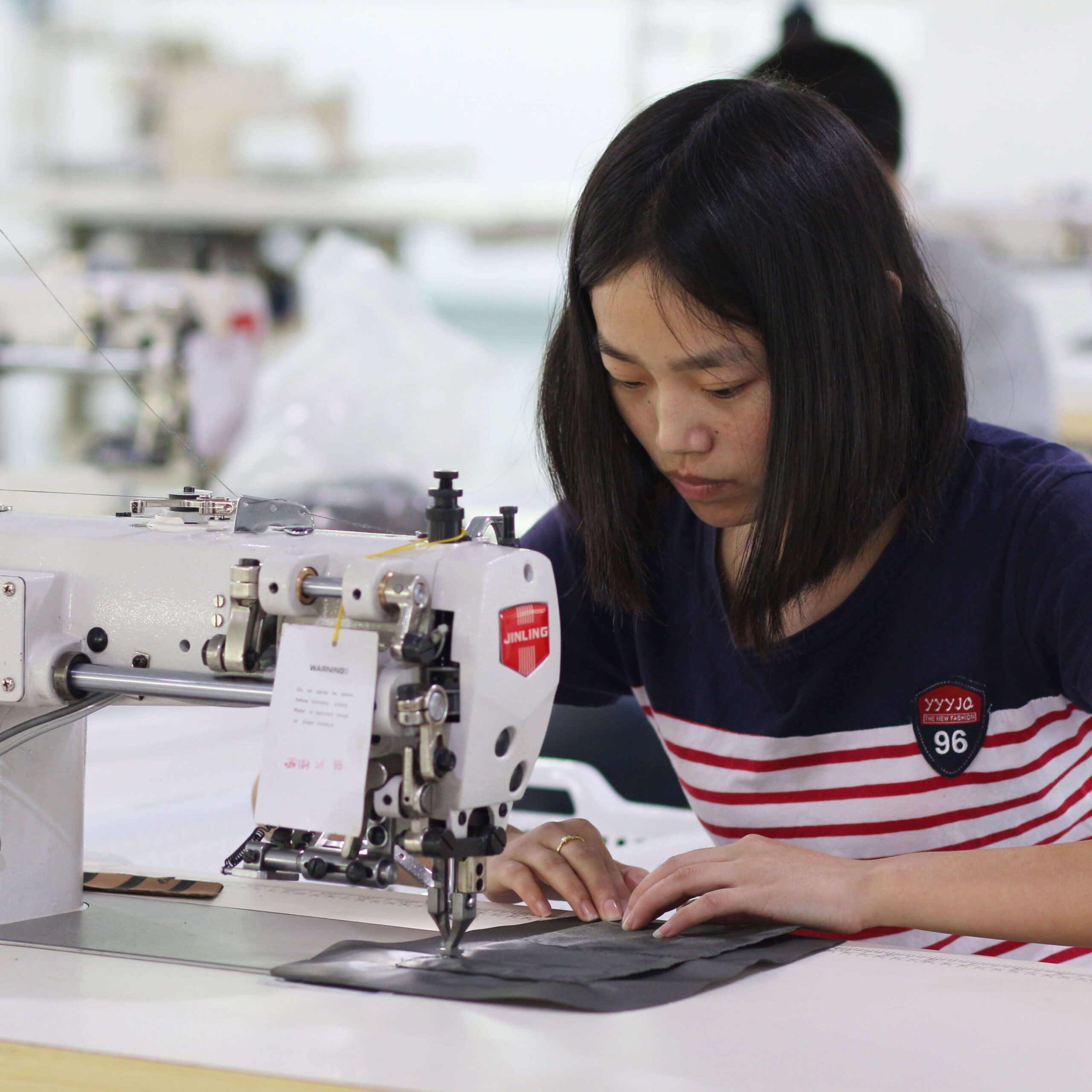 Skilled seamstresses sewing organic cotton tote bag panels with reinforced stitching at Ecoicolortote factory in Dongguan