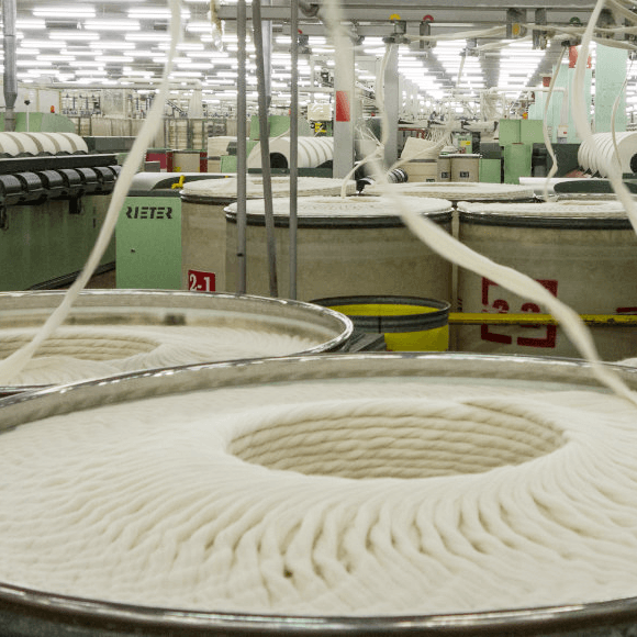 Industrial looms weaving organic cotton canvas fabric in natural and dyed colors
